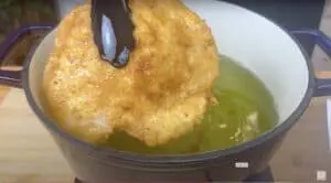 Crispy breaded schnitzel frying in a hot oil pan, golden brown and delicious.